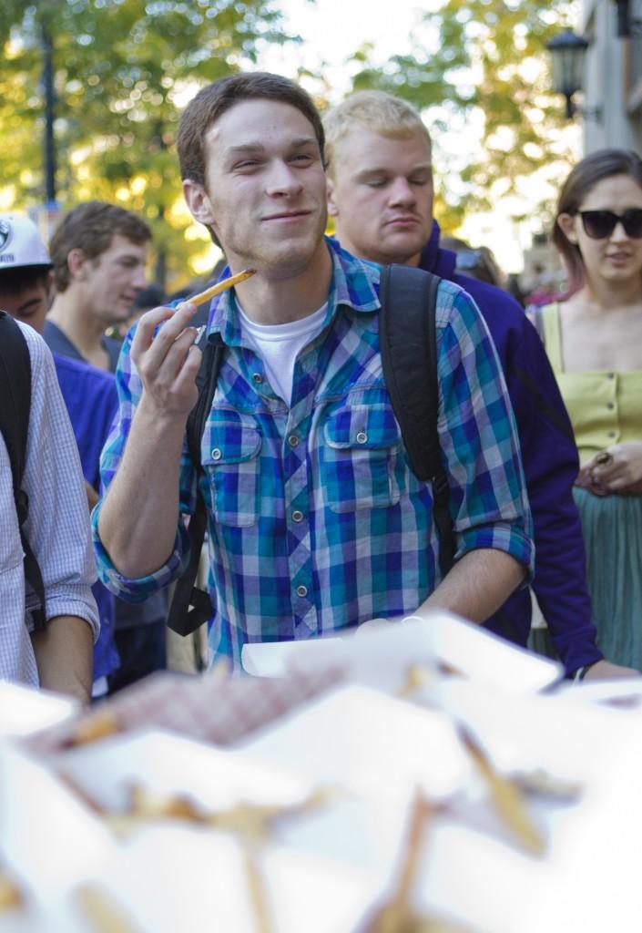 Communication junior Scott Wolf eats truffle fries from Edzos Burger Shop in downtown Evanston during Sundays Big Bite Night. This year, over 30 different restaurants participated in the annual event.