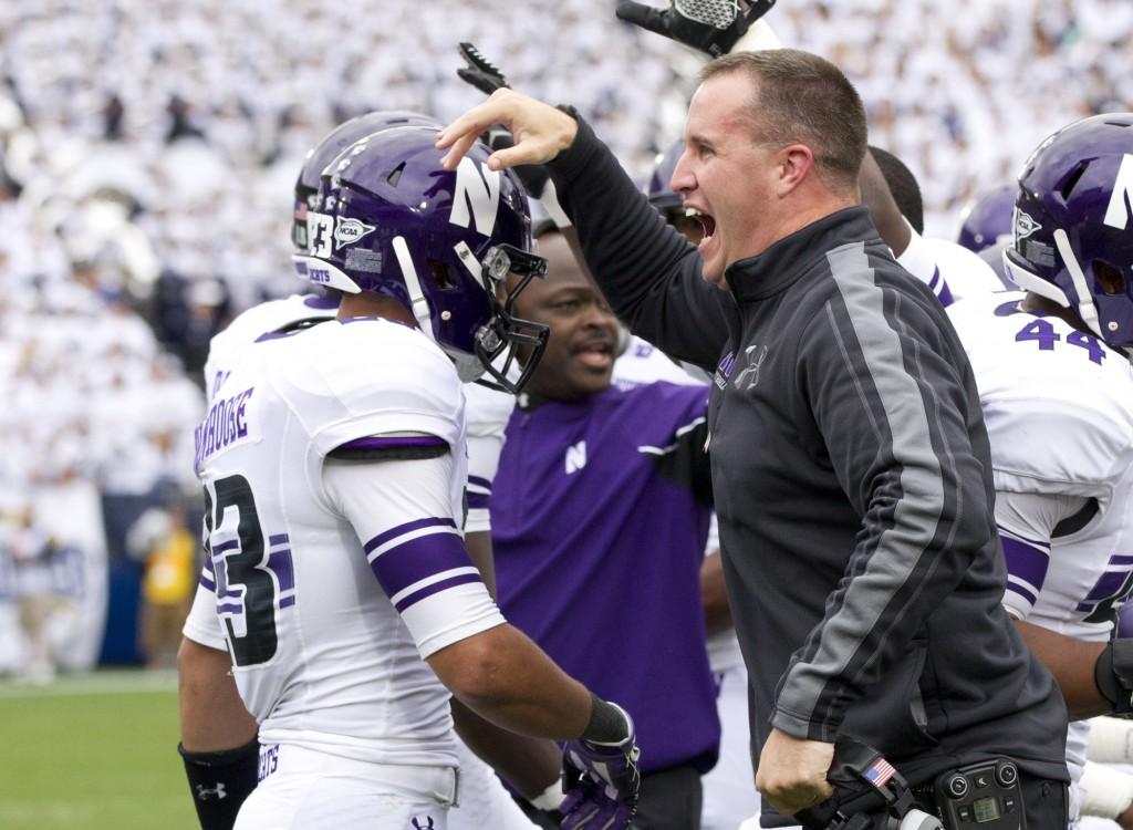 Coach Pat Fitzgerald celebrates after redshirt freshman Nick VanHoose recovers a fumble. The takeaway led to NUs first touchdown.