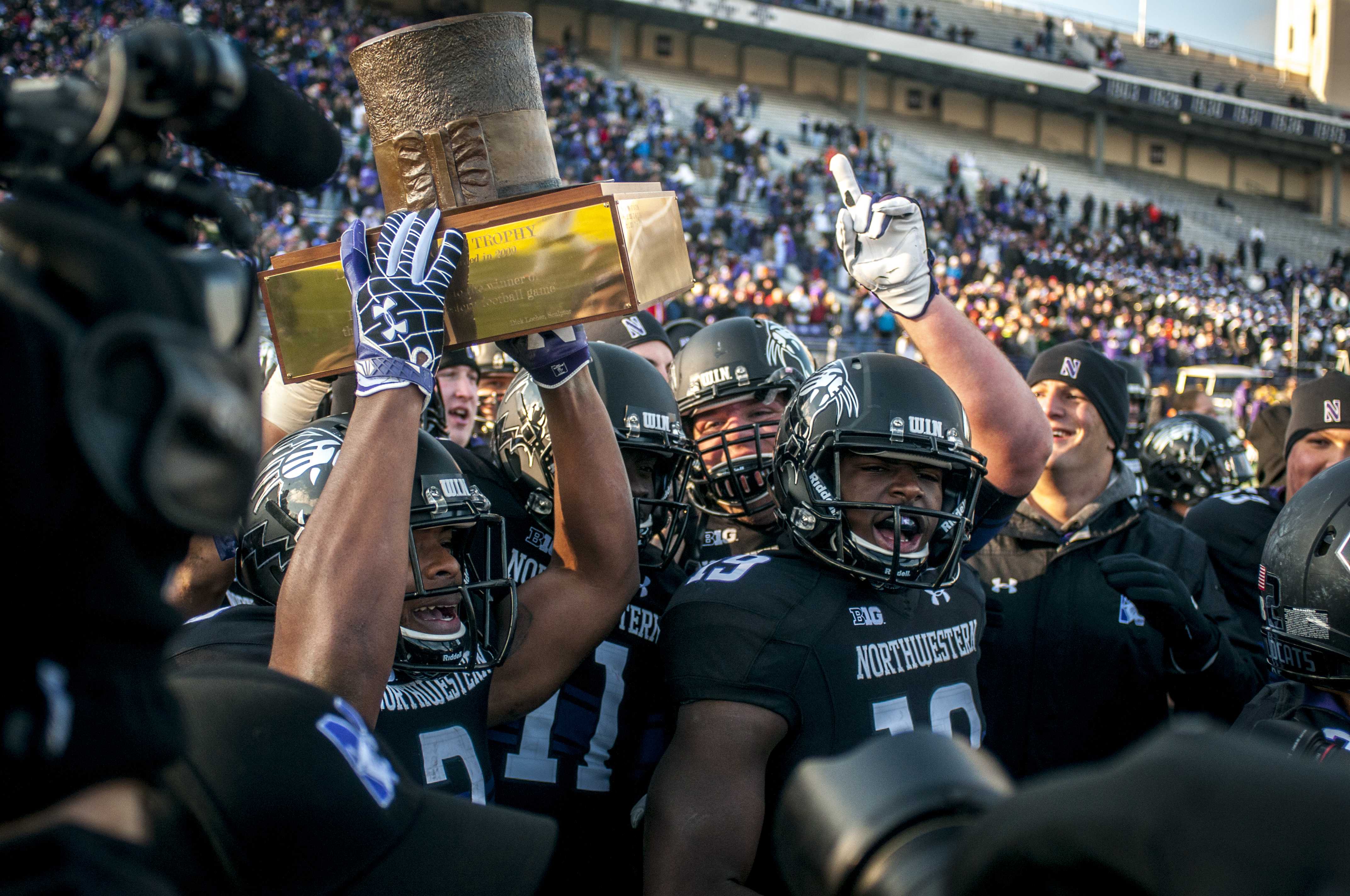 Northwestern Wildcats hoist the Land of Lincoln Trophy after defeating Illinois 50-14 on Saturday at Ryan Field.