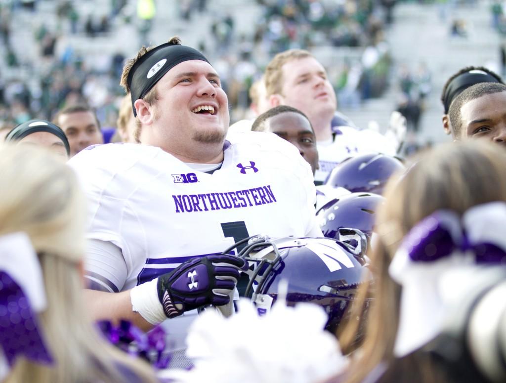 Northwestern defensive lineman Bo Cisek (1) sings the NU fight song with fans after the Wildcats 23-20 win over Michigan State on Saturday. The Cats have now improved their record to 8-3.