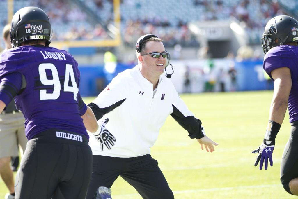Northwestern coach Pat Fitzgerald congratulates his defense after senior defensive end Quentin Williams returned an interception 29 yards for a touchdown. The Wildcats used the score to help give them a 13-0 lead, but NU now leads 13-10 at halftime.
