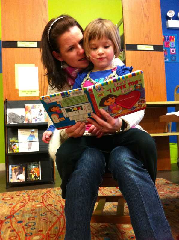 Evanston resident reads a story to her 3-year-old at the Chicago-Main branch of the Evanston Public Library on Saturday, the same day the former Mighty Twig reopened as an EPL branch.