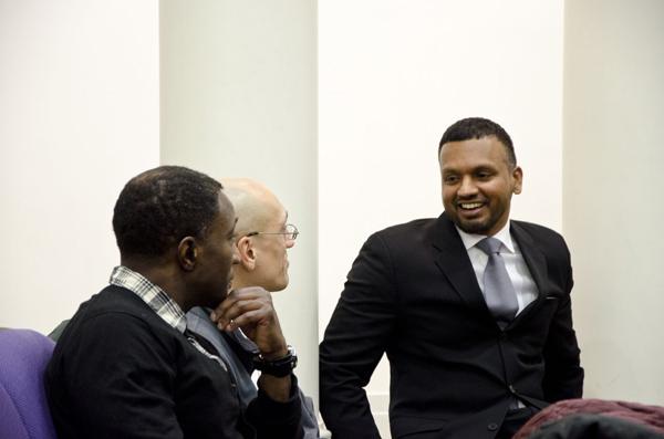 Zaheer Ali, who was part of the Malcolm X project at Columbia University, speaks with (from left) Loyola Prof. Kim Searcy and Evanston resident Eric Basir.