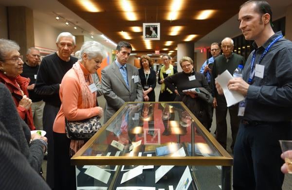 James Rosen (gray suit) examines artifacts at the Patricia Neal exhibit as NU librarian Benn Joseph (right), the exhibits curator, relates the stories behind them.