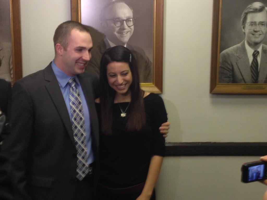 Evanston Police officer Sean OBrien and his girlfriend Mallory Navarra pose for photos outside the city council chamber. Evanston officials recognized OBrien on Monday night for pulling a young child out of the Des Plaines River while off-duty last week.