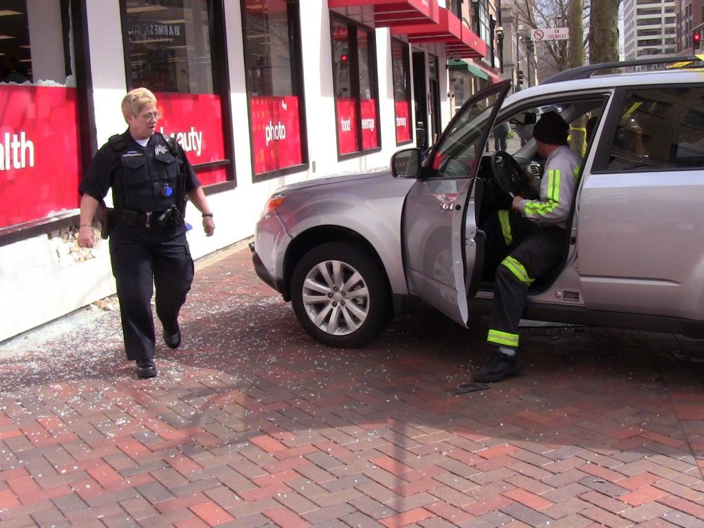 Evanston Police inspect the scene where a 74-year-old woman drove her van into the CVS in downtown Evanston, breaking the stores window and damaging part of its brick wall.