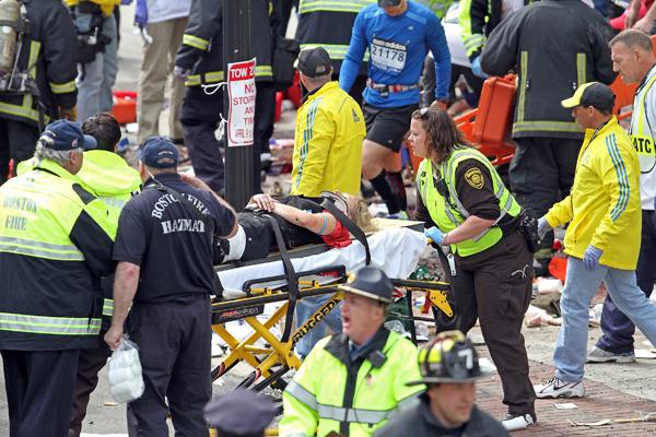 Emergency personnel assist the victims at the scene of a bomb blast during the Boston Marathon in Boston, Massachusetts, Monday, April 15, 2013.
