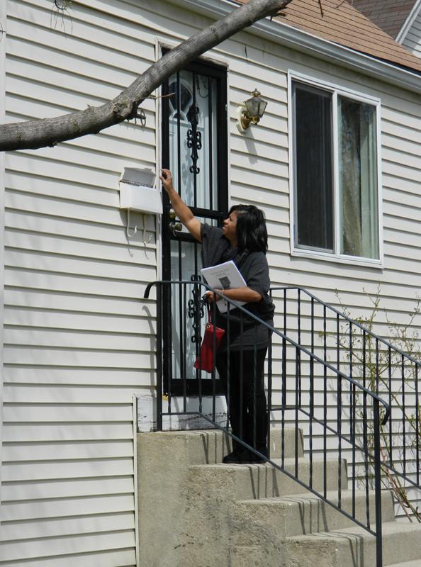 Evanston resident Cathy Key flyers in the 1800 block of Brown Street, where Evanston teenager Justin Murray was shot dead in November. Key and other Evanston residents volunteered Saturday with Cook County Crime Stoppers to gather information for the ongoing investigation into Murray's death.