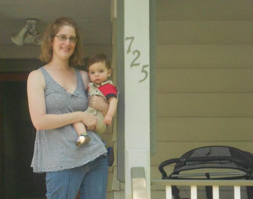 Megan Abraham holds her son Leo on the front porch of their home in the  700 block of Noyes Street, where she says two American flags have gone missing. She lives next door to Feinberg Prof. Mark Waymack, who resigned from Northwestern earlier this month, citing student misconduct in the neighborhood. 