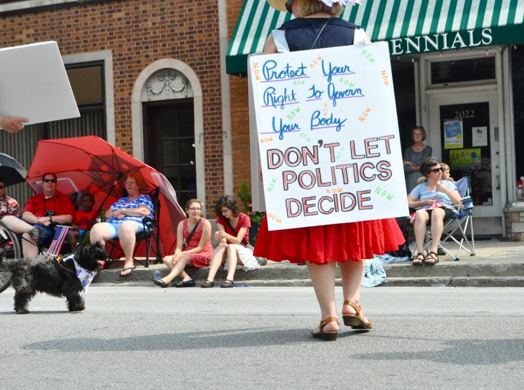 A representative from the National Organization for Women joins other groups advocating for abortion rights, including the Pro-Choice Coalition, in Evanstons July Fourth parade on Thursday. Some residents said the parade has gotten too political in recent years.