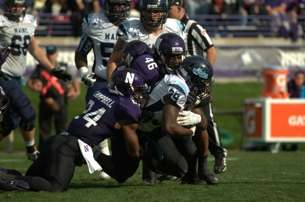 Junior safety Ibraheim Campell and senior linebacker Damien Proby tackle Maines Rickey Stevens to the dirt. The Northwestern defense proved to be the strong side of the team Saturday, earning two interceptions and scoring on both turnovers.