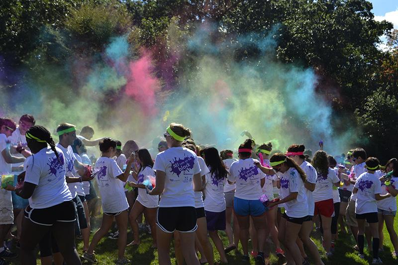 Students gather in cloud of color that covers Deering Meadow. Students embraced the NU Cats on the Block Homecoming theme as a 90s playlist played at the event Sunday.

