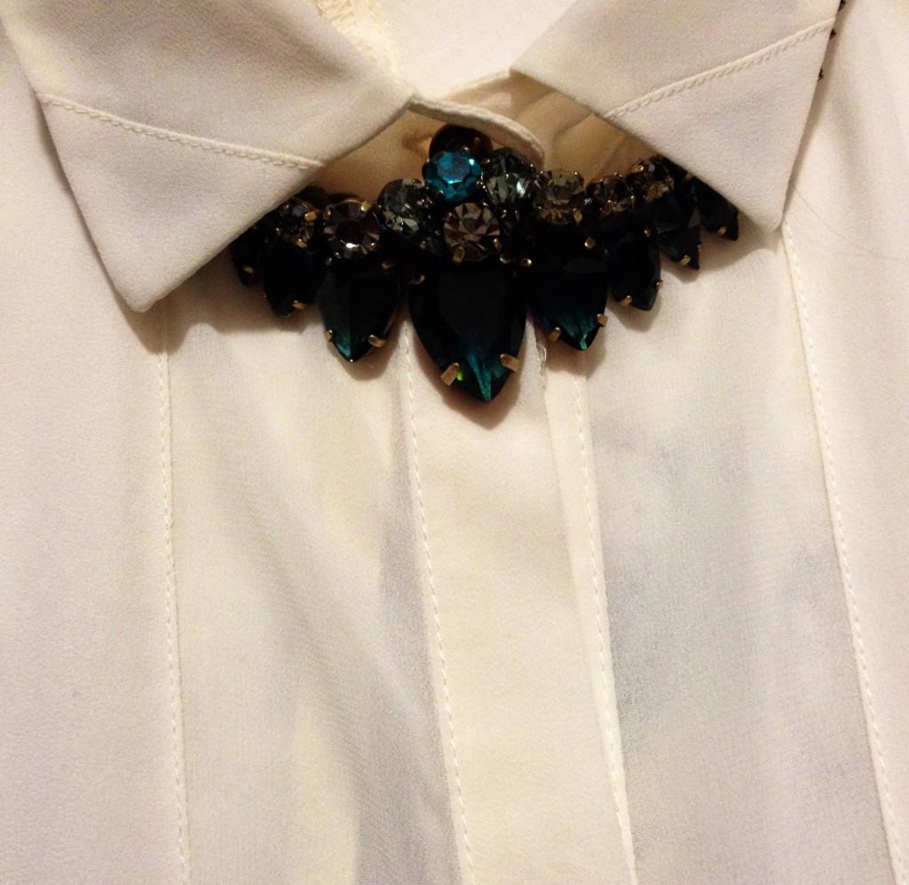Buttoned-up collars feel edgier with a tough necklace.