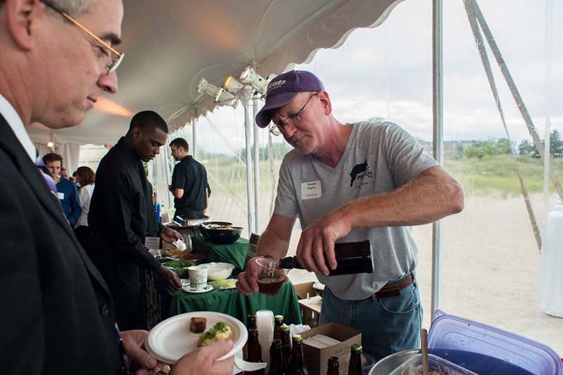 Tom Fogarty, the brewmaster of Peckish Pig, pours a sample of brown ale at Northwestern’s beachfront in a community gathering event in September. The restaurant will be the first brewpub in Evanston with a scheduled Dec. 1 opening. 
