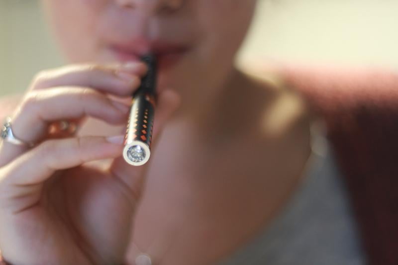 A Northwestern student smokes an electronic cigarette. Evanston City Council is considering banning the battery-powered devices from all places where other types of smoking are prohibited.
