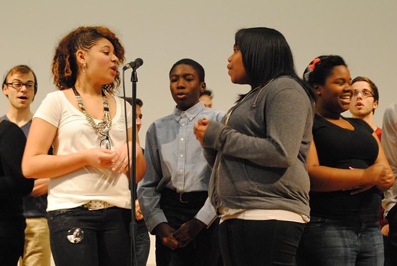 Evanston Township High School sophomores Leslee Muckleroy (left) and Angela Zachery sing Bill Withers Lean on Me. The group of students in the ETHS a capella group performed at a Martin Luther King Jr. Day community event organized by Youth Organizations Umbrella.