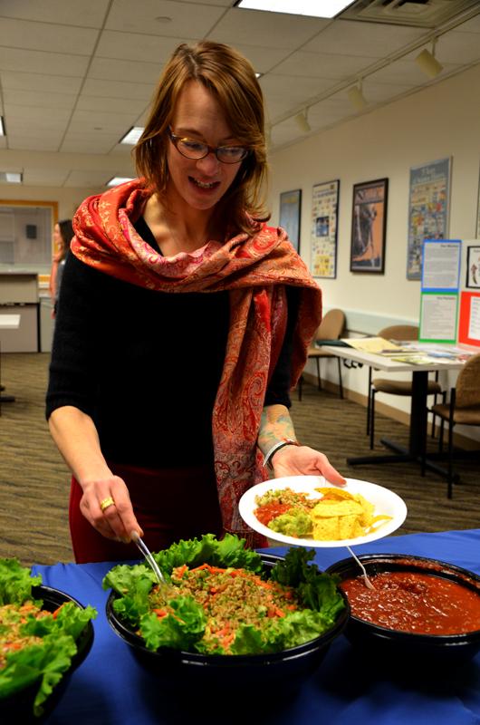 Northwestern University staff member A.C. Racette helps herself to food at an NU Sustainable Food Talk. The event included a potluck and panel about the business of good food sourcing.