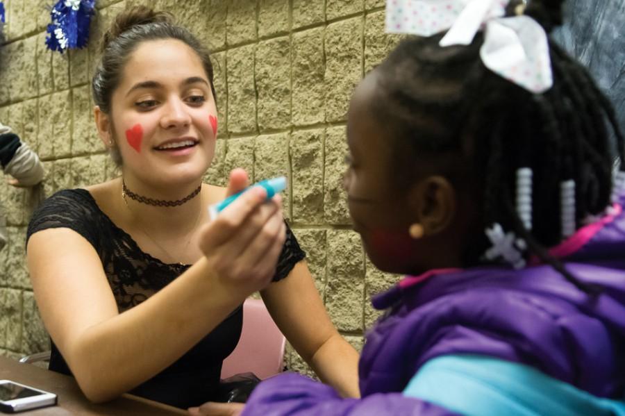 Communication freshman Allison Towbes paints the face of a trick-or-treater at Project Pumpkin on Thursday night. The event, sponsored by Northwestern Community Development Corps, provided trick-or-treating and games for Chicago-area children.