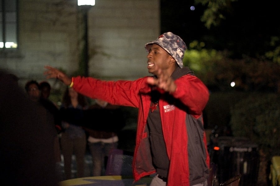Student performer Prez Harris (McCormick sophomore Randall Harris) raps Wednesday night at The Rock as part of a demonstration to express anger over the shooting of an unarmed black teenager in Ferguson, Missouri in August. About 50 students attended the event, wearing red armbands and listening to student musical and spoken-word acts. 