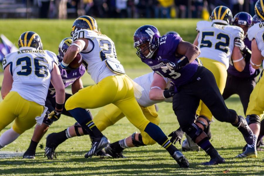 Junior defensive end Deonte Gibson lunges at a Michigan ball-handler. When not battling injuries, Gibson has provided steady play on the defensive line during his three years on the field for Northwestern.