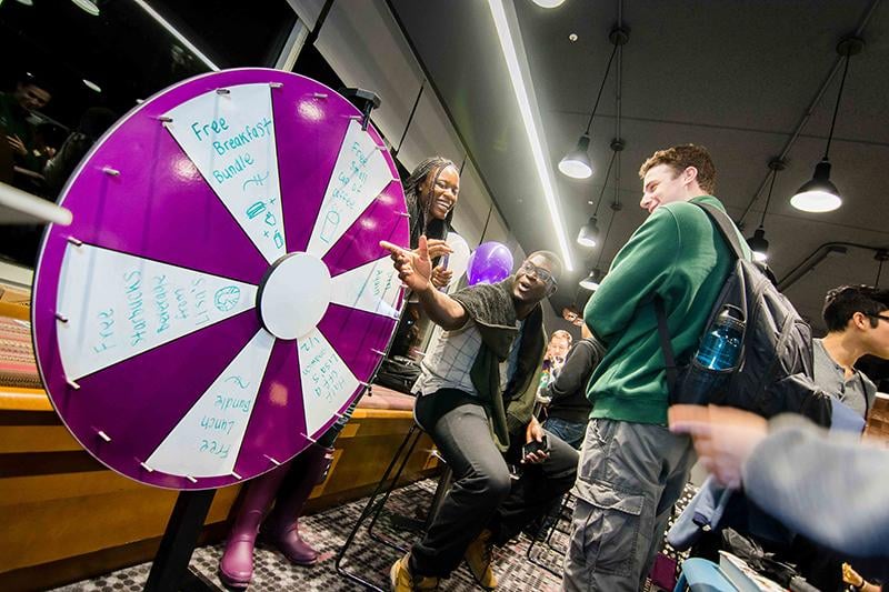 Students spin the wheel for a chance to win free products at a reopening event at Lisa’s Cafe on Wednesday. Lisa’s recently underwent renovations, added to its menu and extended its hours.