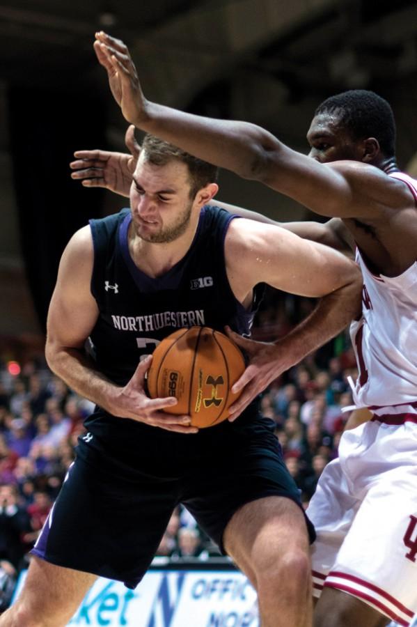 Alex Olah muscles his way around a defender. The junior center is expected to play a larger role in his second year in coach Chris Collins’ system.