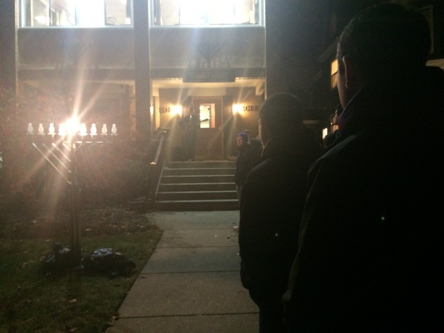 Medill sophomore Noah Fromson plays a song Tuesday night on the steps of the Tannenbaum Chabad House, 2014 Orrington Ave. About 50 student representative gathered and spoke about tolerance at the commemoration of the Chabad Houses new menorah, which was replaced after it was vandalized in October.
