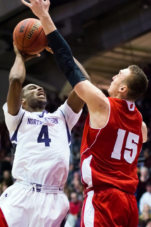 Vic Law attempts a shot against Wisconsin forward Sam Dekker. The freshman has struggled to adjust offensively to the college game, but his athletic ability is still shining through for the Cats.
