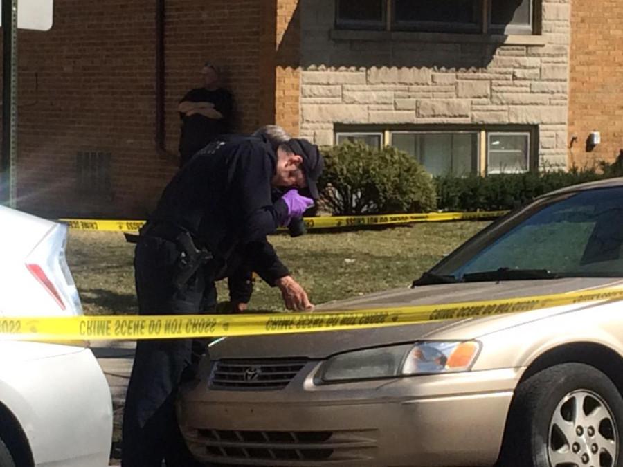 Evanston police examine the car hit by a stray bullet in the 300 block of Custer Avenue. Two men were later arrested in connection with shots fired calls. 