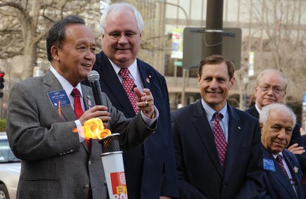 Rotary International president Gary Huang lights the Rotary Flame outside One Rotary Center on Tuesday as other RI leaders look on. The Flame signifies RI’s recent victory in their 30-year-long fight to eradicate polio worldwide with the declaration of India as a polio-free zone.