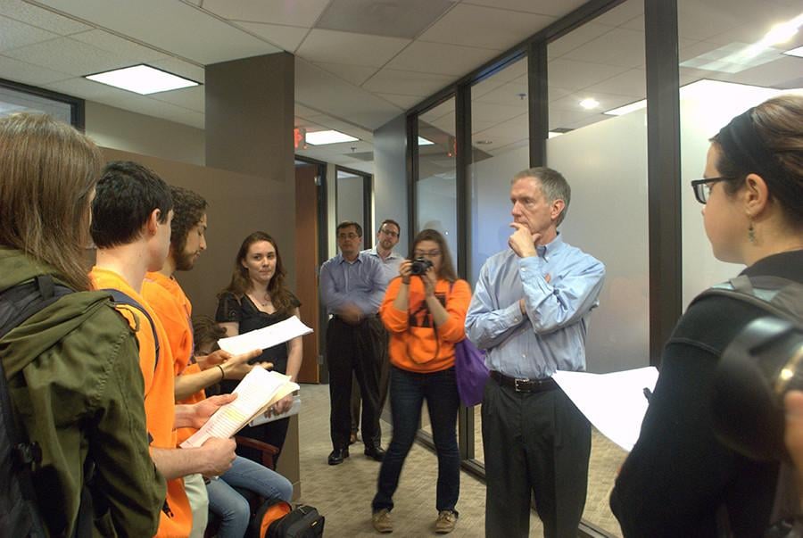 Members of Fossil Free NU read from a prepared statement on Wednesday in front of Will McLean (right), Northwesterns chief investment officer. The group handed hundreds of letters to McLean showing student support for coal divestment.