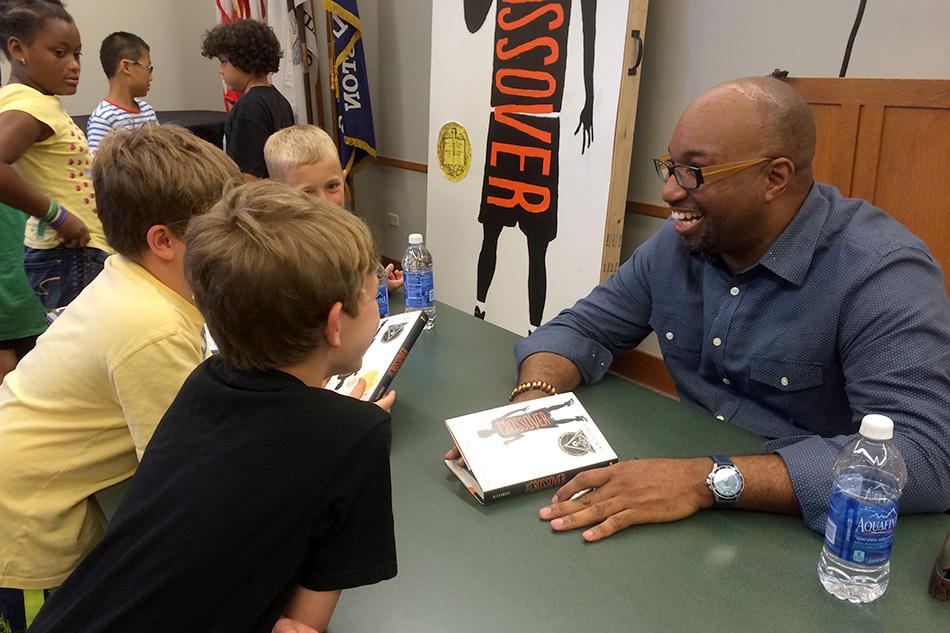 Kwame+Alexander%2C+this+years+Newbery+Medalist%2C+signs+copies+of+his+award-winning+book+Thursday+afternoon+at+the+Evanston+Public+Library.+Alexanders+book%2C+called+The+Crossover%2C+is+a+childrens+novel+about+basketball-playing+twins+that+is+written+entirely+in+verse.+