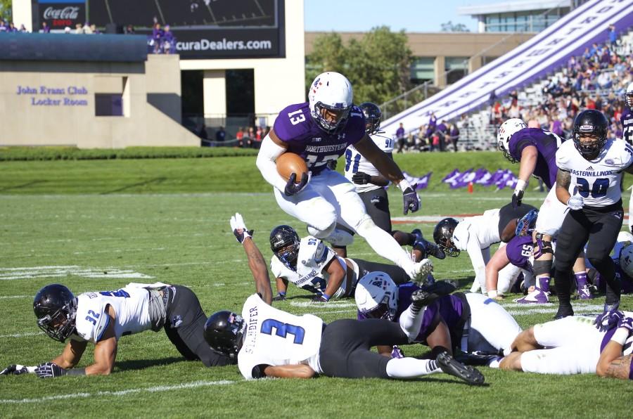 Running back Warren Long leaps over diving Eastern Illinois defenders. The junior would finish with 72 rushing yards on the day, contributing to the Wildcats dominant offensive performance. 