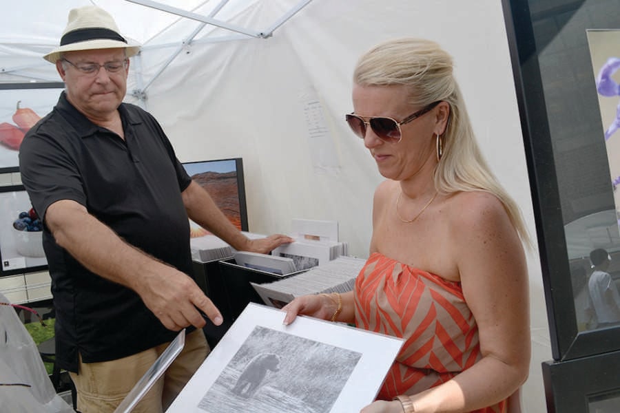 Jerry Alt (left), an Evanston-based photographer, shows his nature photography alongside his business partner Annette Patko at a June art festival in the city. Alt is debuting on Sunday a collection of his photography from his trip to Cuba.