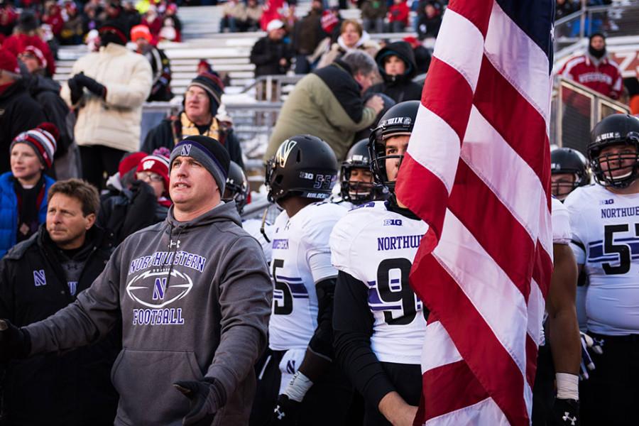 A bundled-up coach Pat Fitzgerald and the Northwestern football team get ready to take the field against Wisconsin. The Wildcats are bound for the warmer weather of Tampa, Florida, and the Outback Bowl. 
