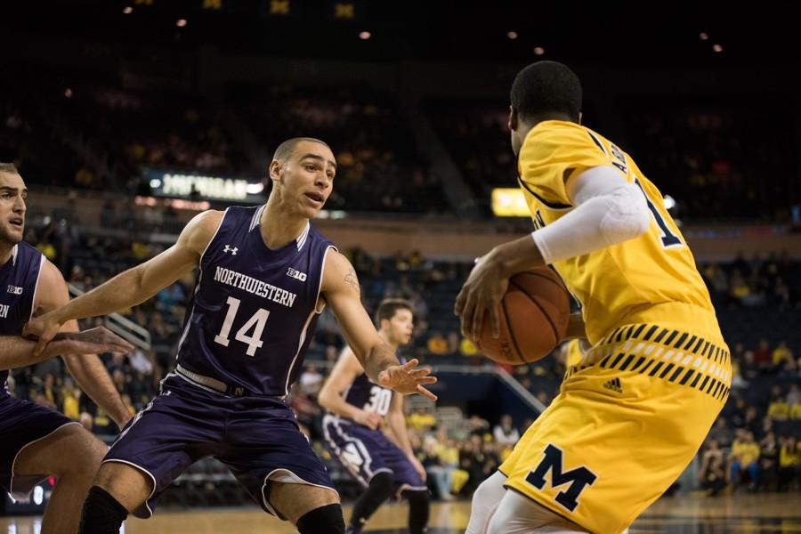 Tre Demps tries to keep up with a Michigan player. The senior guard was the only Wildcat to make all of his free throws Wednesday, going 2-for-2 from the line.