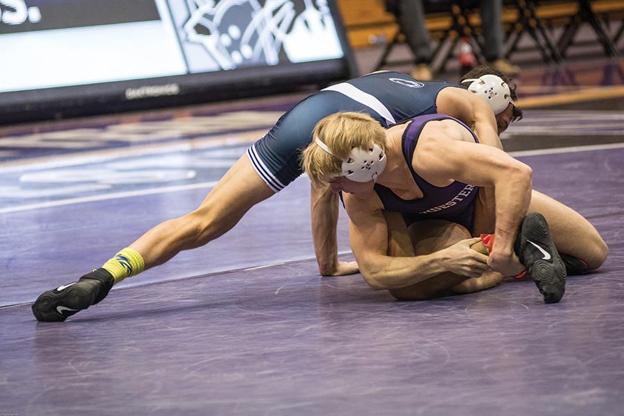 A Northwestern wrestler grabs an opponent’s leg. The Wildcats will host their final home dual of the season Friday against Duke.