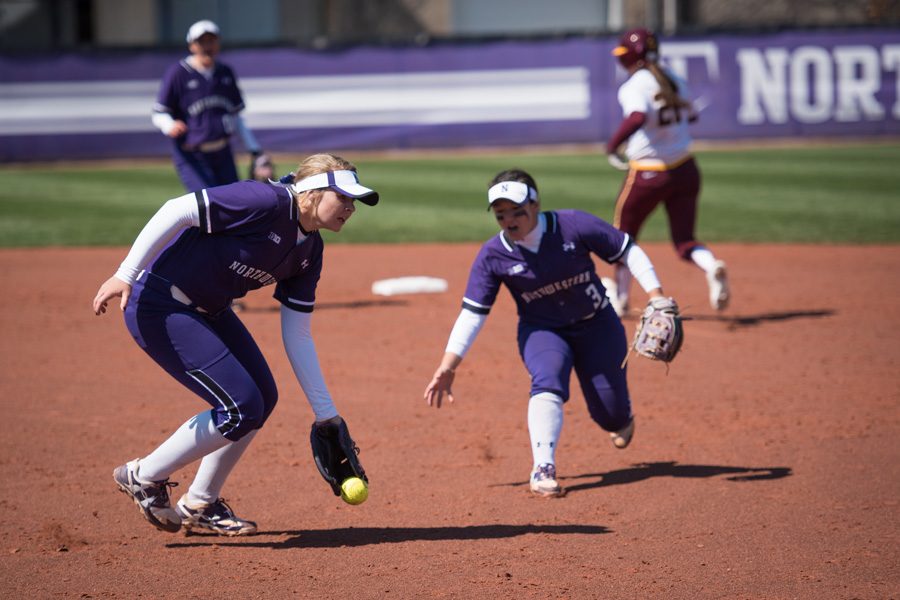 Kenzie Ellis (left) fields the ball from the circle. The freshman pitcher tossed six innings in Thursdays doubleheader nightcap. 