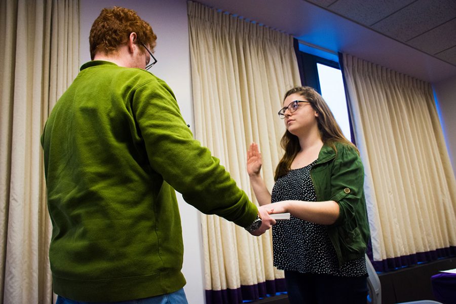 Former Associated Student Government president and Weinberg senior Noah Star (left) swears in the new president, SESP junior Christina Cilento, and executive vice president Macs Vinson, a McCormick junior. Star told senators in a farewell address to take their jobs seriously and represent students well.