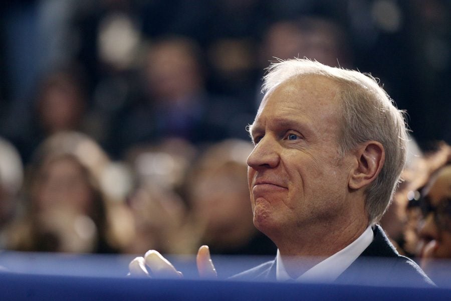 Gov. Bruce Rauner listens to President Barack Obama speak in Chicago. Rauner will not attend the Republican National Convention this year.