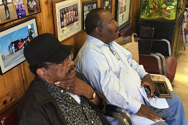 Samuel Johnson Jr., left, sits in his barbershop, located at 1905 Church St. The block of Church Street on which the barbershop sits will be named Samuel Johnson Place, after City Council approved the decision by unanimous vote on June 13. 