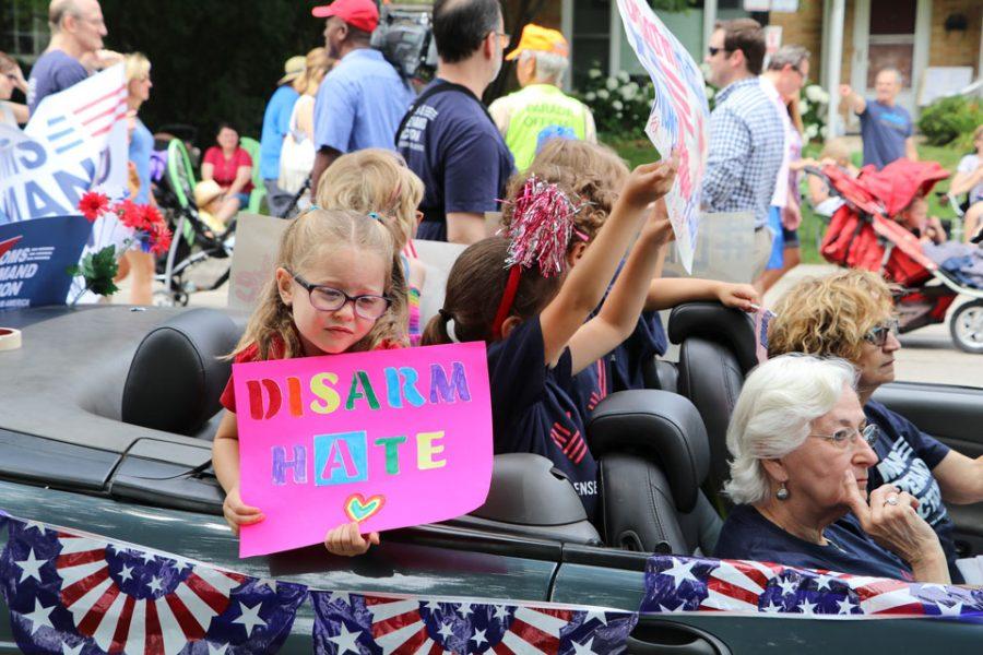 Members of Evanstons Moms Demand Action for Gun Sense in America and young children hold signs as they take part in the citys Fourth of July parade. This is the first year the group brought a float to accompany participants as they marched the parade route.