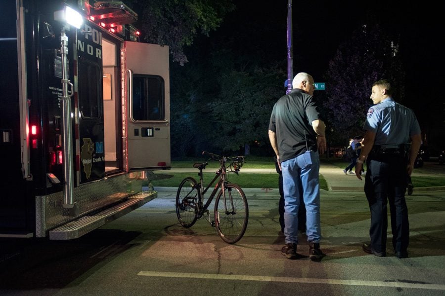Police stand next to an ambulance and bike involved in an accident on Sheridan Road Thursday. An 18-year-old Northwestern student was killed after an accident with a cement truck while biking.