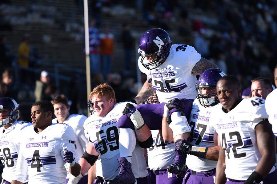 Northwestern players lift a teammate on their shoulders in 2016. The National Labor Relations Board’s general counsel said in a memo that college football players at private universities can seek certain employee benefits.