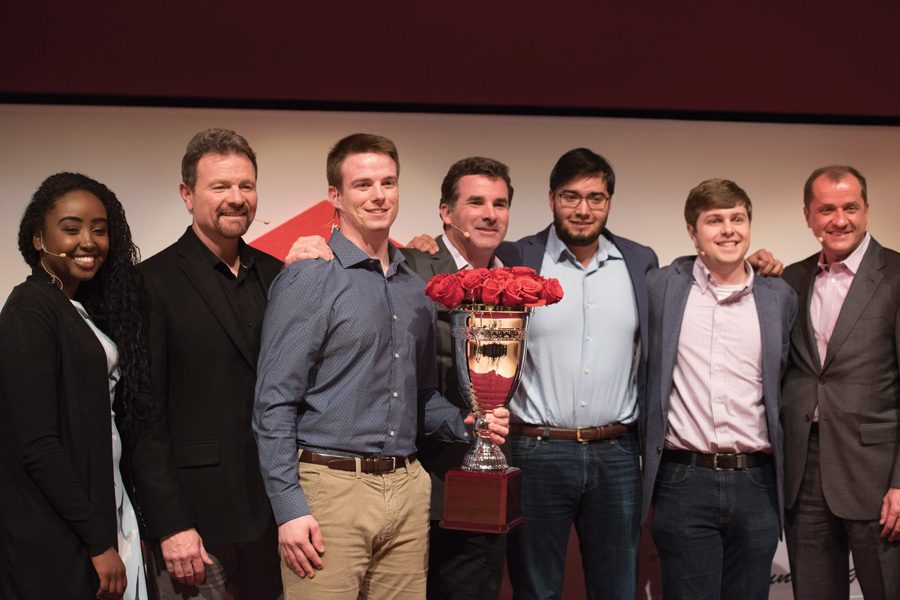 SwineTech founder Matthew Rooda stands with judges and other contestants at the Cupid’s Cup Entrepreneurship Competition. SwineTech, which developed technology to prevent piglet deaths in pig farms, won the $75,000 grand prize. 