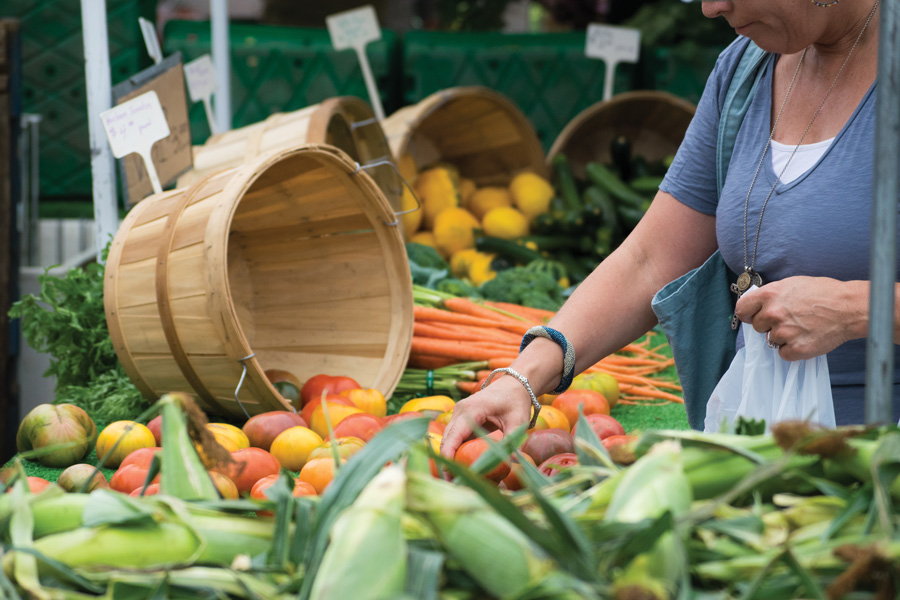 A woman peruses  different vegetable options. The city will now match 100 percent of Link funds at Evanston farmers’ markets this season in an effort to make locally grown fruits and vegetables more accessible to low-income customers. 