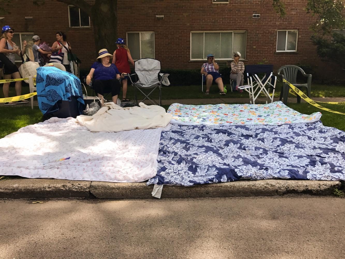 Carolyn Golmon, 74, guards her spot to watch the Evanston Fourth of July Parade. She and other attendees pick their spots, sometimes days in advance, and reserve them using chairs and blankets. 