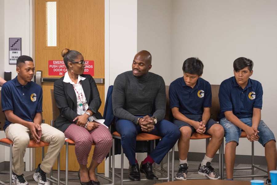 Augustine Emuwa sits with Melinda Jean-Baptiste and students from Gale Community Academy in 1838 Chicago on Thursday. Emuwa discussed problems the students often face, such as income inequality and violence. 