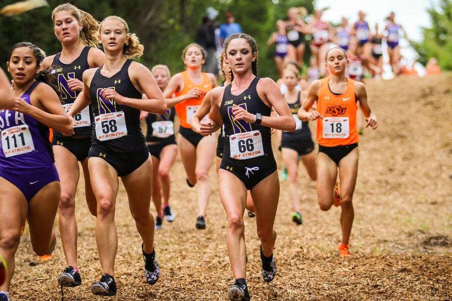 Amanda Davis (right) runs next to two teammates. The freshman and the Wildcats will head to Indiana this weekend for the Big Ten Championships.