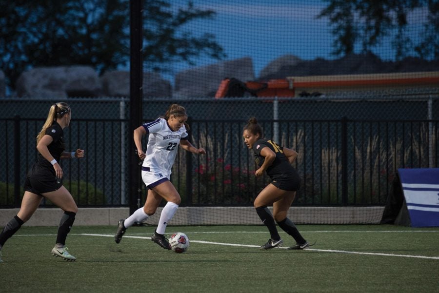 Brenna Lovera runs between two defenders. The junior forward and the Wildcats earned an at-large bid to the NCAA Tournament and will play Butler on Sunday. 